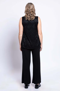 Back view of a woman wearing a sleeveless black lace tank top and pants