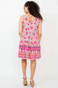 Back view of woman wearing sleeveless dress with crisscross detail and floral pattern.