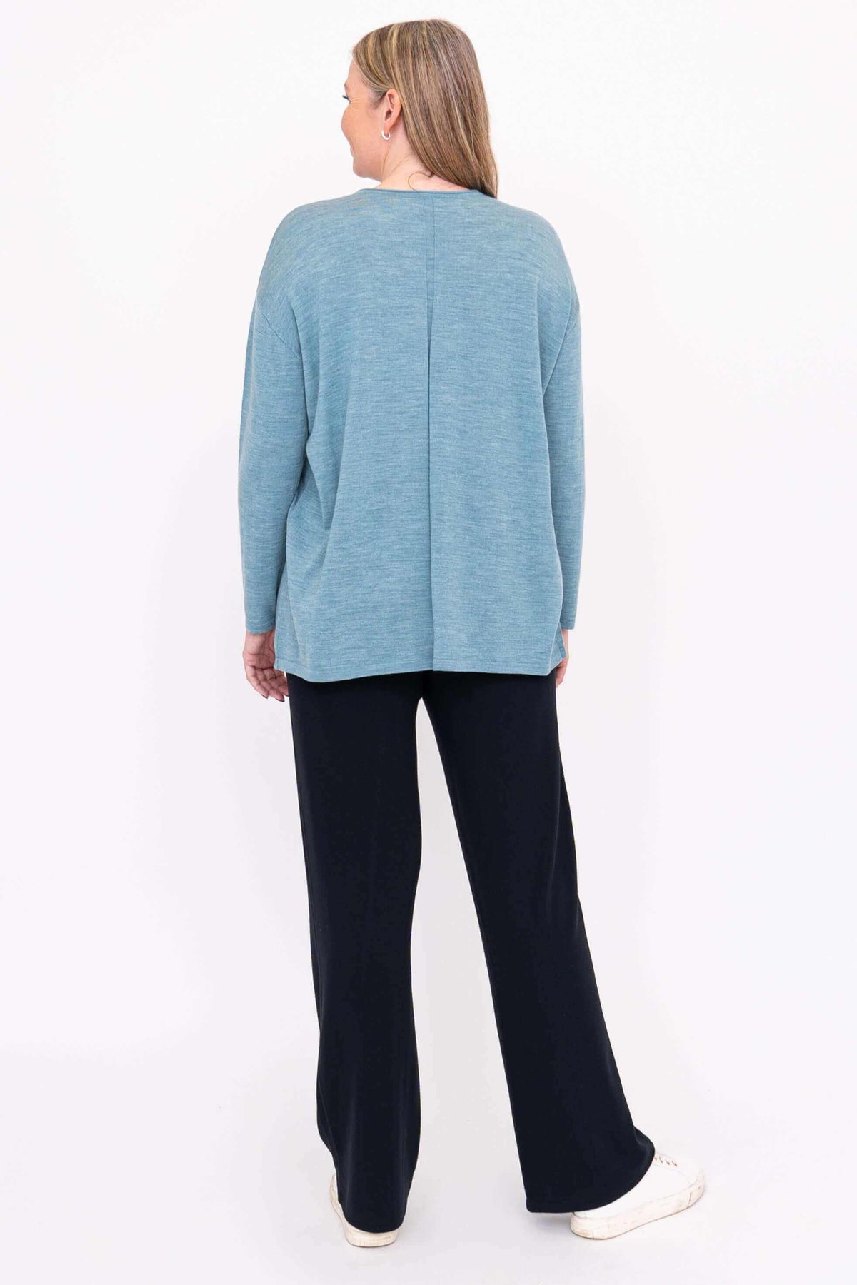 Back view of woman in light blue Merino wool sweater showing rear seam detail