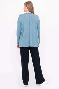 Back view of woman in light blue Merino wool sweater showing rear seam detail
