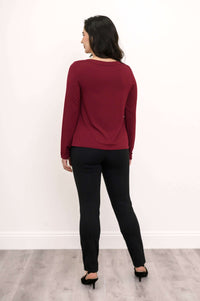 Back view of woman in maroon boat neck top and black pants