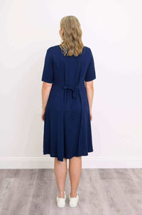Back view of woman in navy dress with tie belt and short sleeves