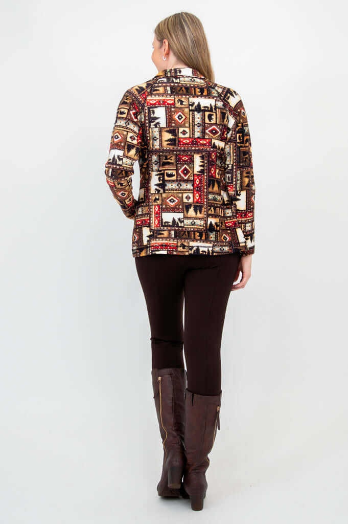 Back view of woman in Sona patterned zip jacket and brown pants with boots