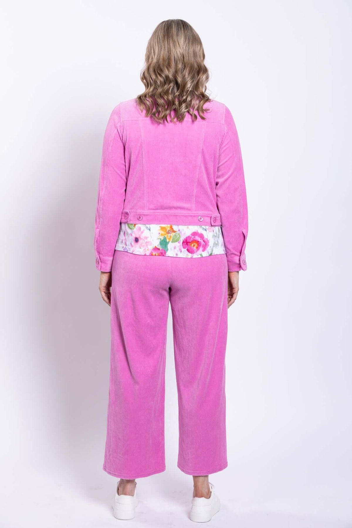 Rear view of woman showing the back of the pink corduroy jacket and pants