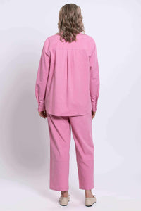 Back view of a woman wearing a pink linen blend shirt and pants set