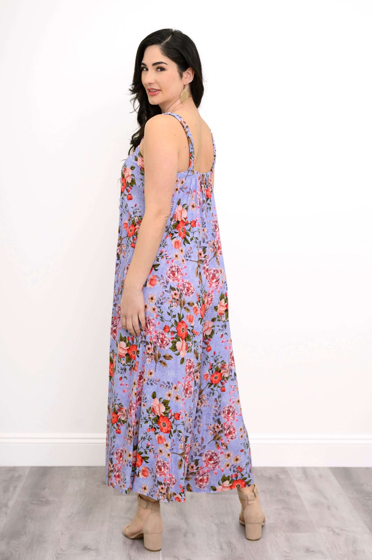 Back view of woman in a sleeveless purple floral jumpsuit with wide legs