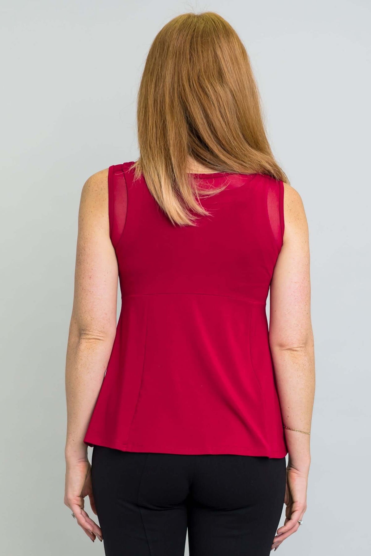 Back view of woman wearing a sleeveless red tank top with mesh detail