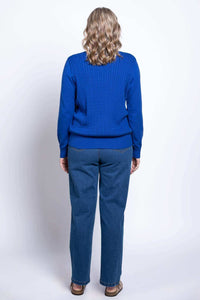 Back view of woman wearing a royal blue cable knit sweater and blue jeans