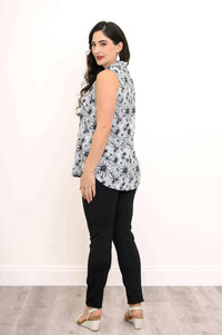 Back view of woman in sleeveless floral tank top and black pants
