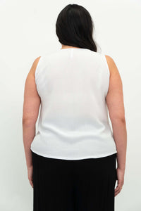 Back view of woman wearing a white sleeveless tank top