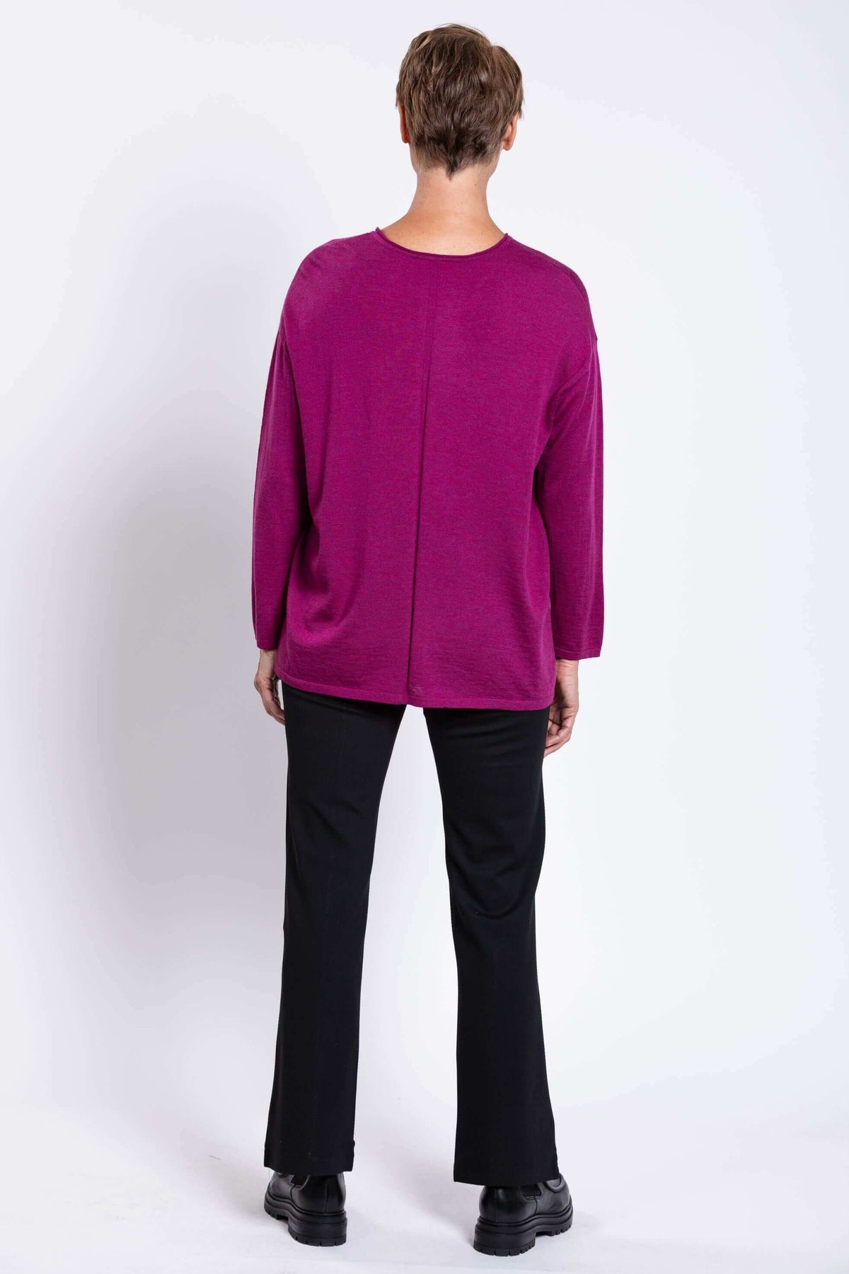 Back view of woman showing split detail of fuchsia Merino wool sweater