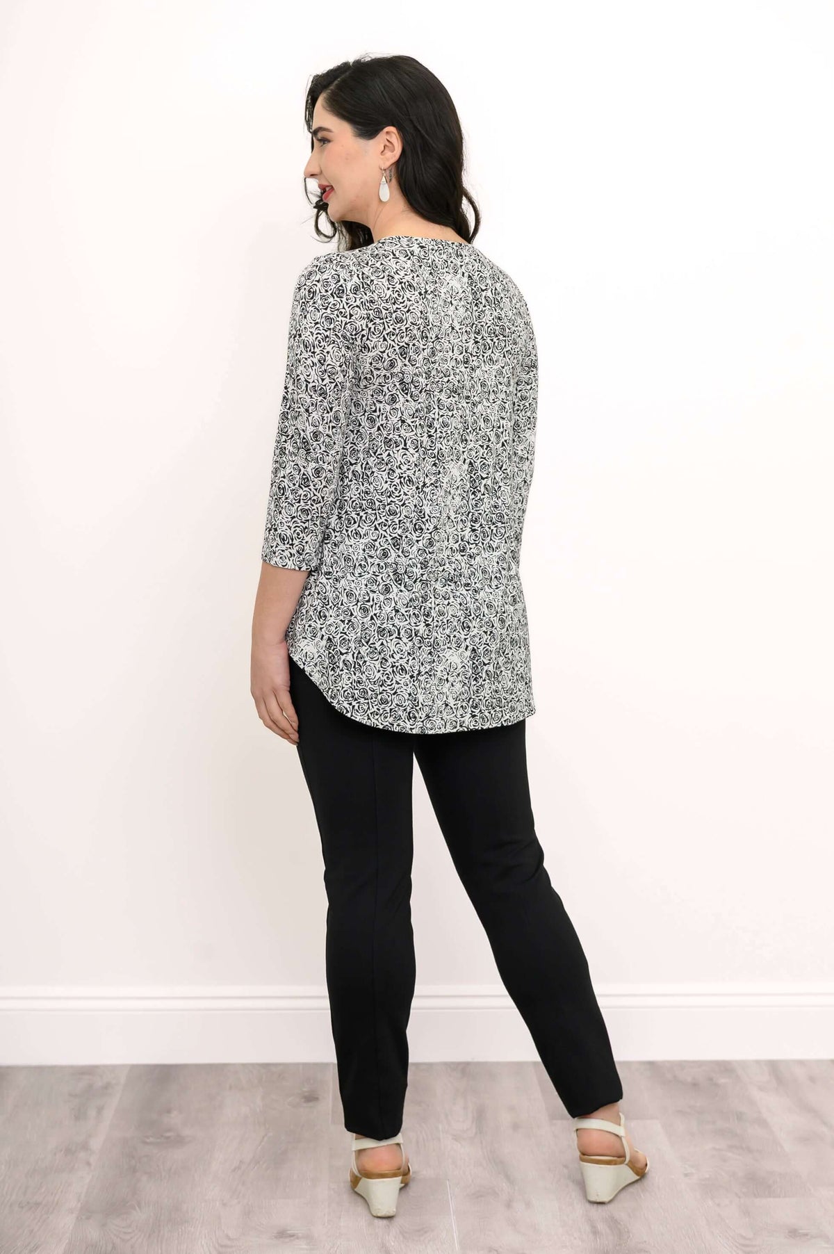 Back view of woman wearing black and white rose print bamboo top