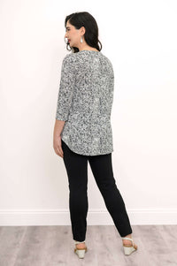 Back view of woman wearing black and white rose print bamboo top