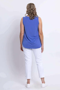 Back view of a woman wearing a blue sleeveless tank top and white pants