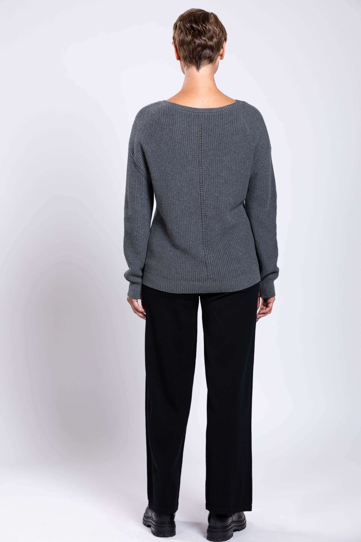 Back view of woman wearing grey cotton sweater showing textured knit