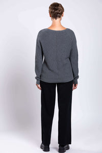 Back view of woman wearing grey cotton sweater showing textured knit