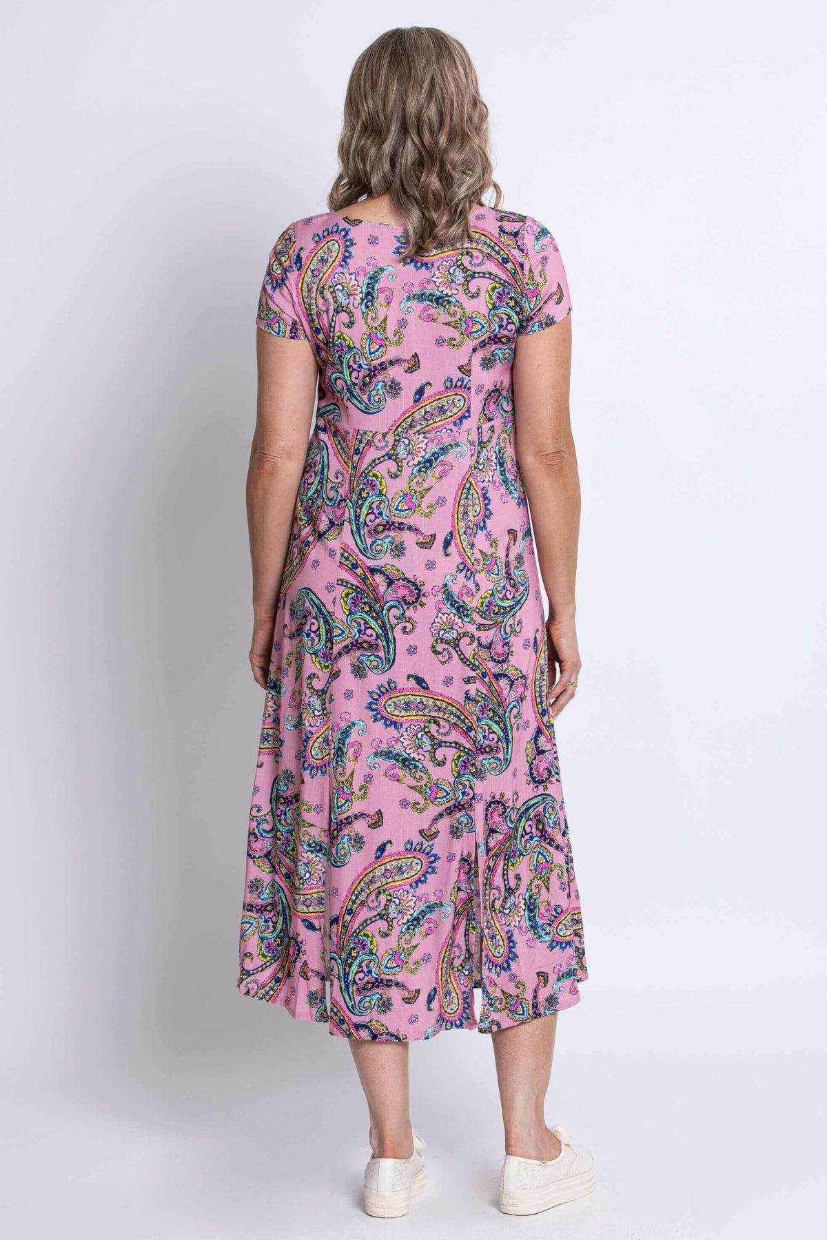 Back view of woman wearing pink paisley midi dress with short sleeves