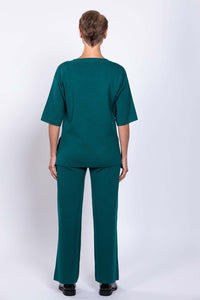 Back view of woman wearing teal short sleeve crew neck sweater with matching pants
