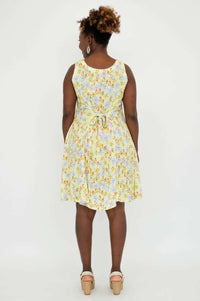 Back view of model wearing yellow floral dress with tie-belt waist
