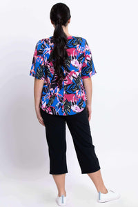Back view showing Liza tropical print blouse and black pants