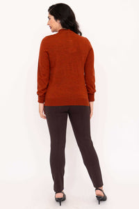 Back view of woman in rust Merino wool cardigan and dark pants