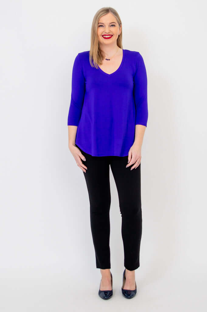 Back view of woman in purple 3/4 sleeve bamboo top showing hemline and relaxed fit