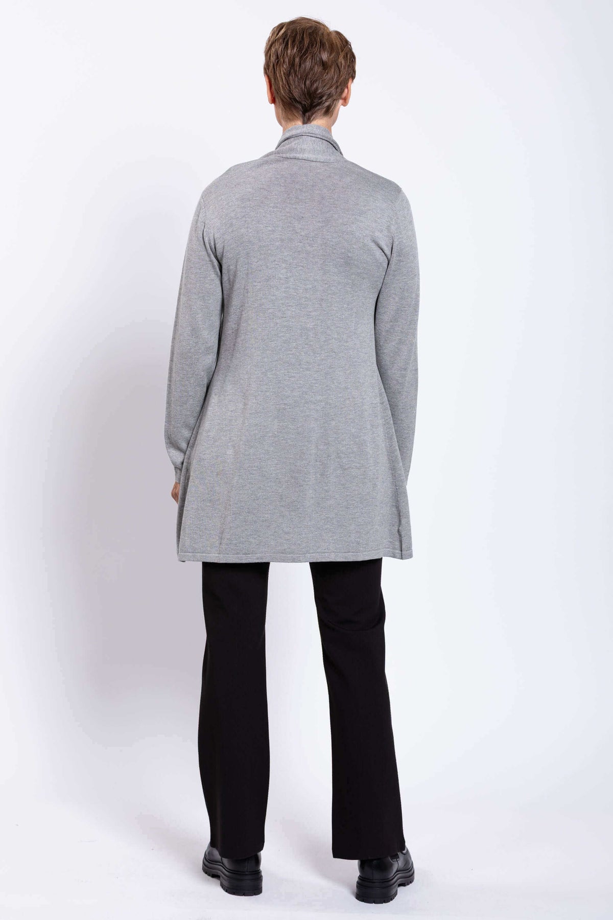 Back view of a woman wearing a long light grey knit cardigan