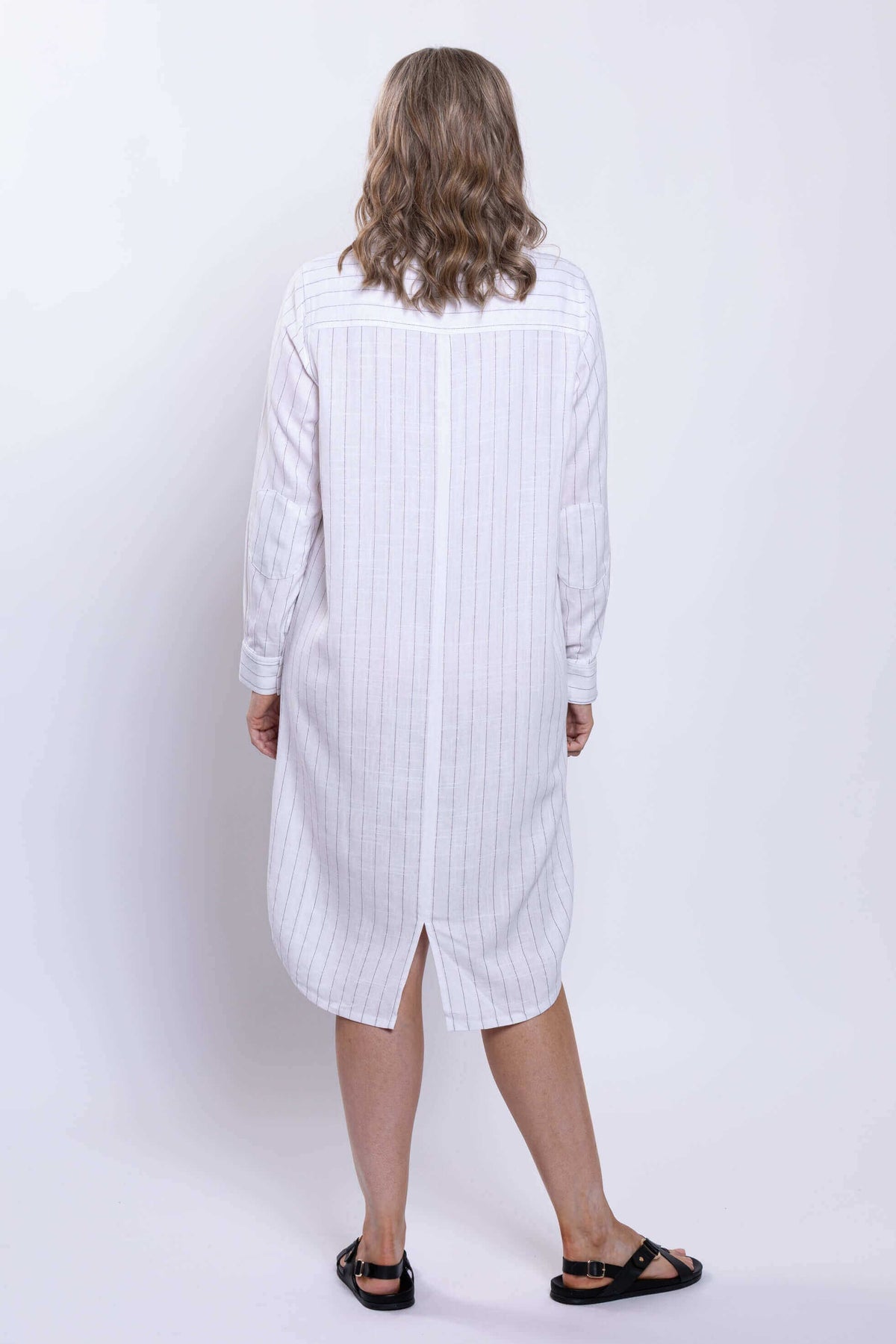 Back view of a striped white duster dress, showcasing the rear slit hem