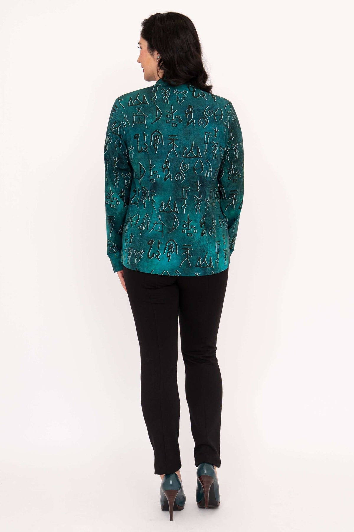 Back view of woman wearing teal blouse with artistic symbol print