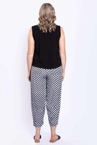 Back view of woman wearing black sleeveless tank top and black-and-white checkered pants