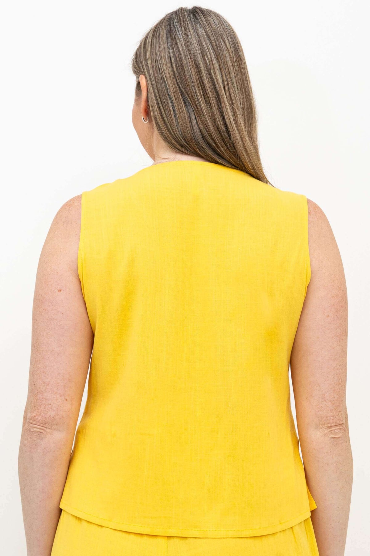 Back view of woman in yellow bamboo-linen cropped tank top