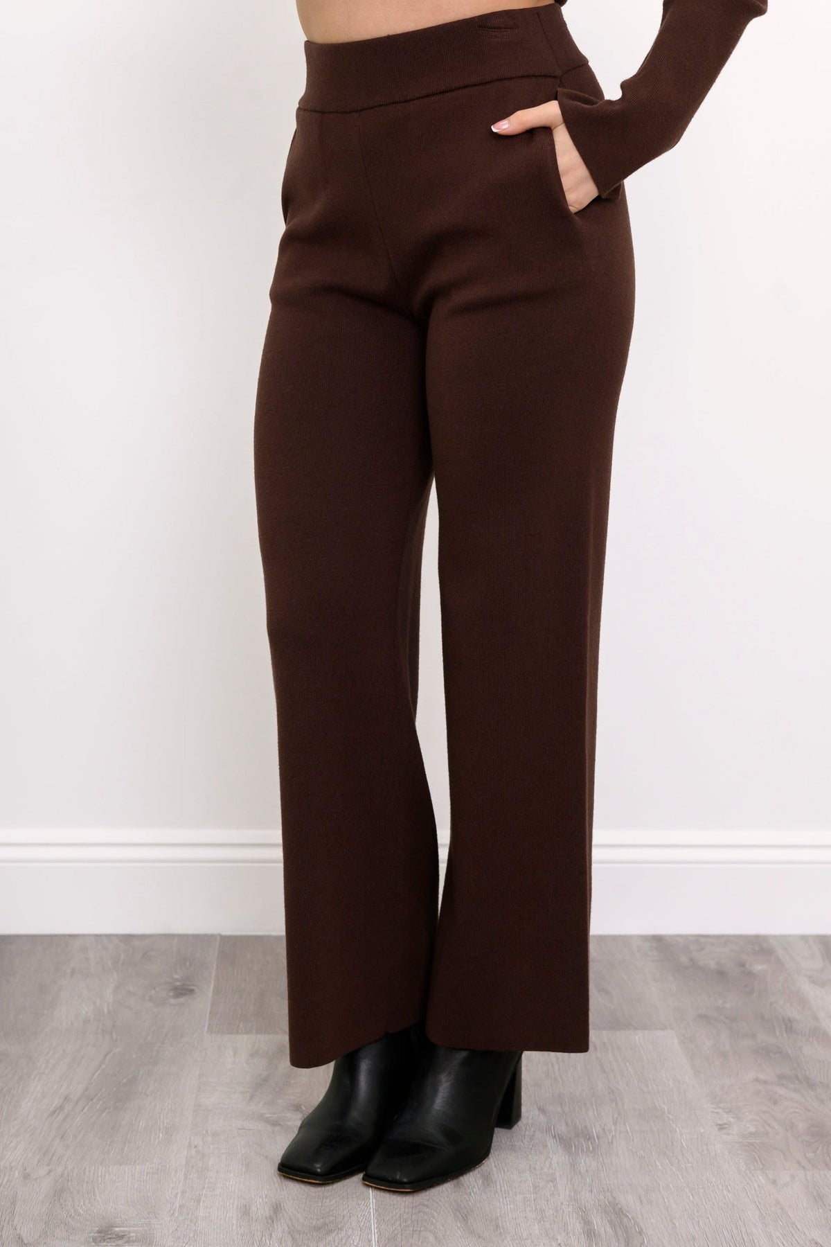 Close-up of women's deep cocoa casual trousers, highlighting the smooth flat waistband and relaxed drape.
