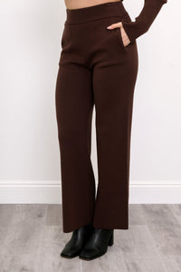Close-up of women's deep cocoa casual trousers, highlighting the smooth flat waistband and relaxed drape.