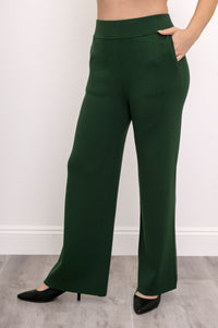 Side view of dark green straight-leg pants on a model, illustrating a clean, pocket-free side silhouette.