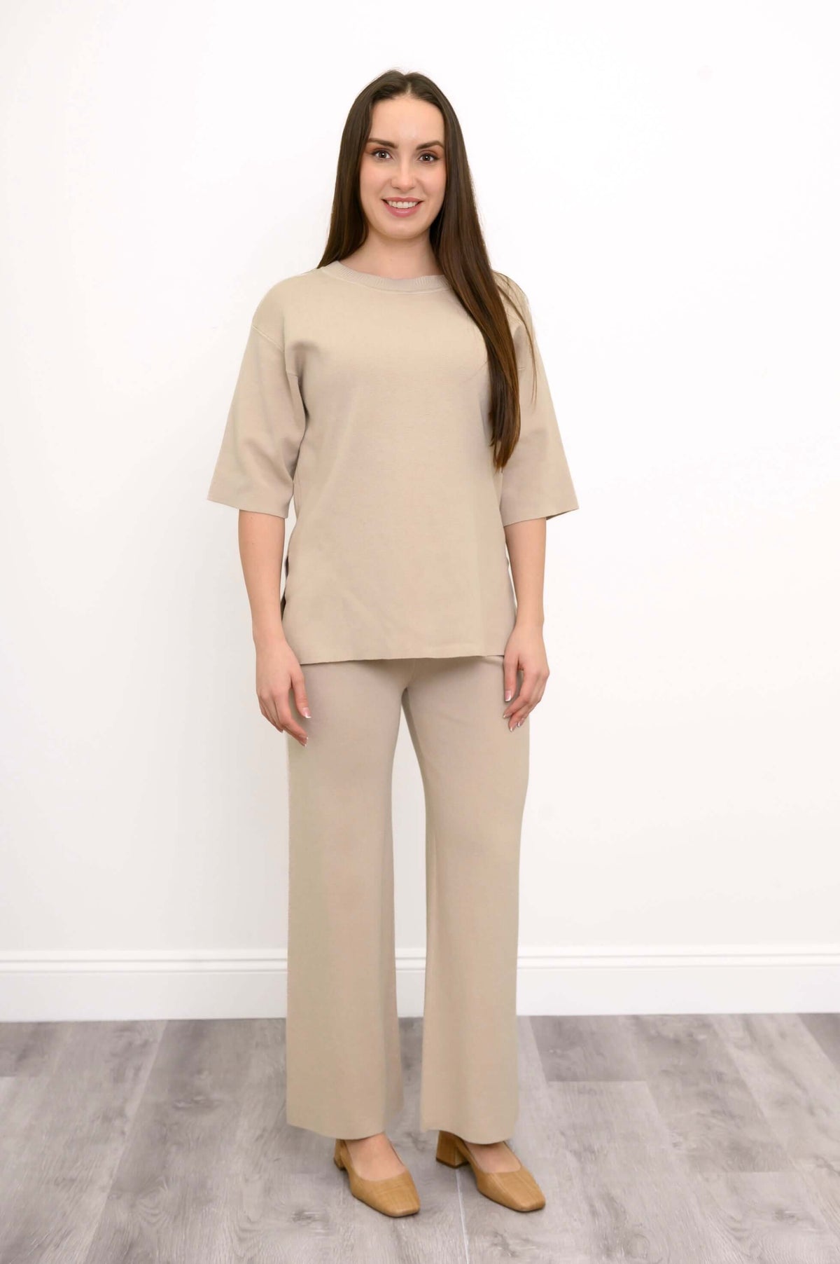 Casual front view of a model in comfortable beige pull on wide leg knit trousers and tan footwear.