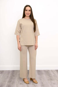 Casual front view of a model in comfortable beige pull on wide leg knit trousers and tan footwear.