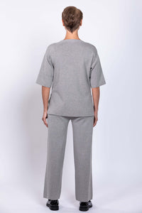 Model wearing Bailey grey track pants and matching top, back view