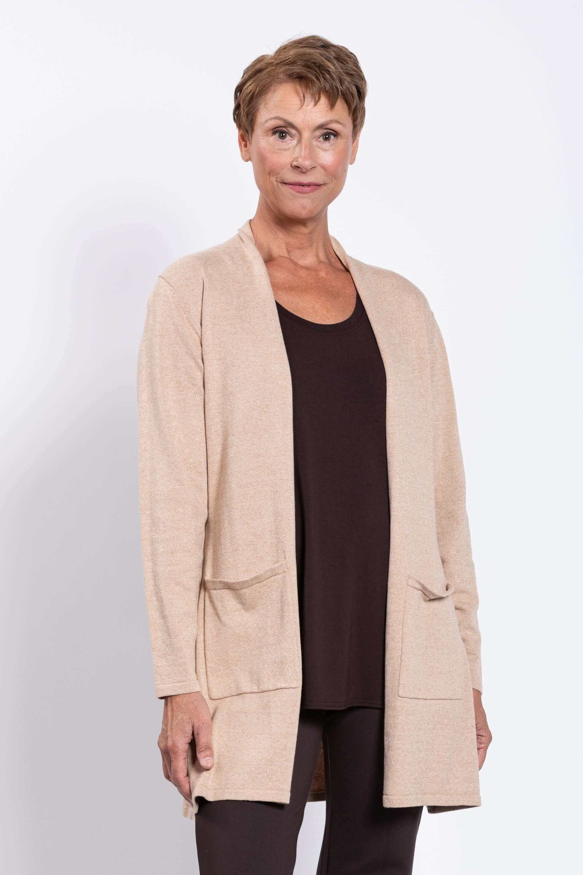 Woman wearing a beige open-front cardigan over a brown top, close-up view