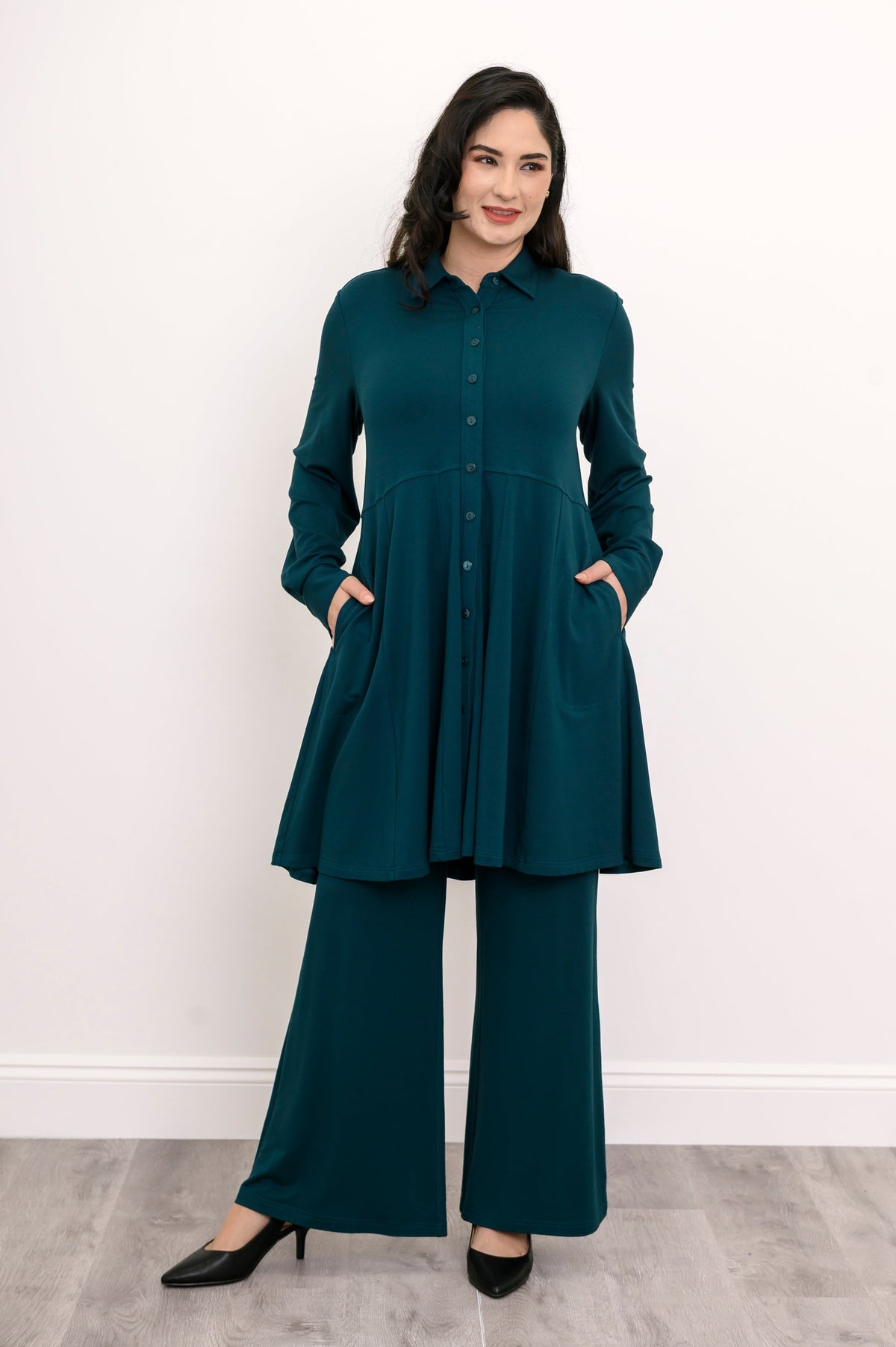Wide shot of a loose-fit teal bamboo tunic shirt grounding the look with a strong vertical button line.