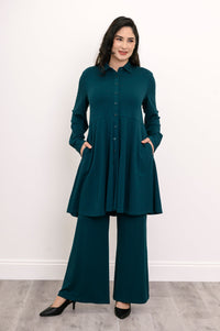 Wide shot of a loose-fit teal bamboo tunic shirt grounding the look with a strong vertical button line.