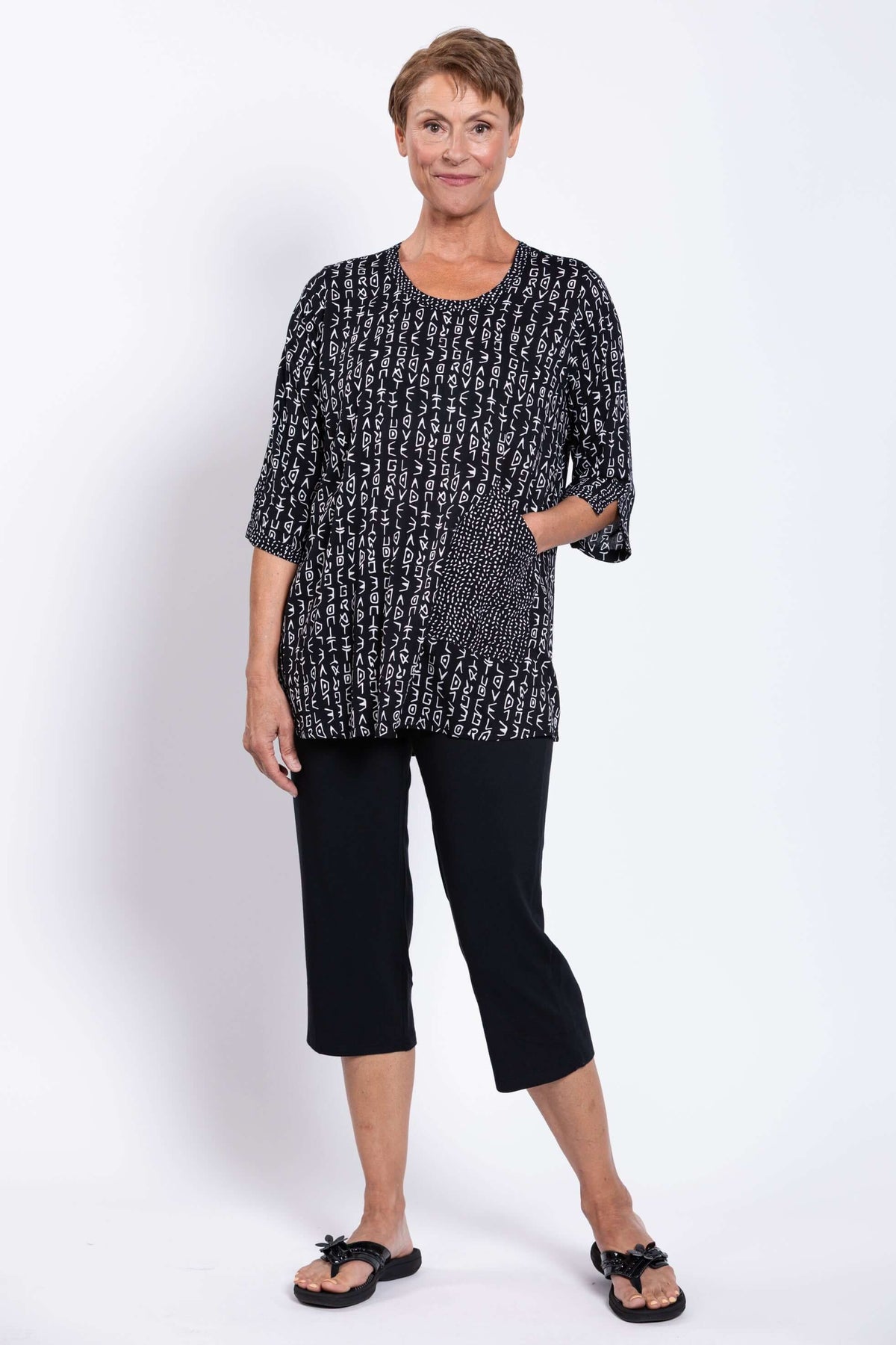 Woman with hand in front pocket, showcasing the unique abstract patterned blouse