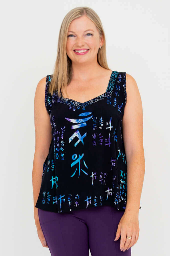Woman wearing a black batik tank top with sweetheart neckline and purple text accents