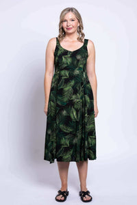Woman in black green leaf print dress styled with a black shrug