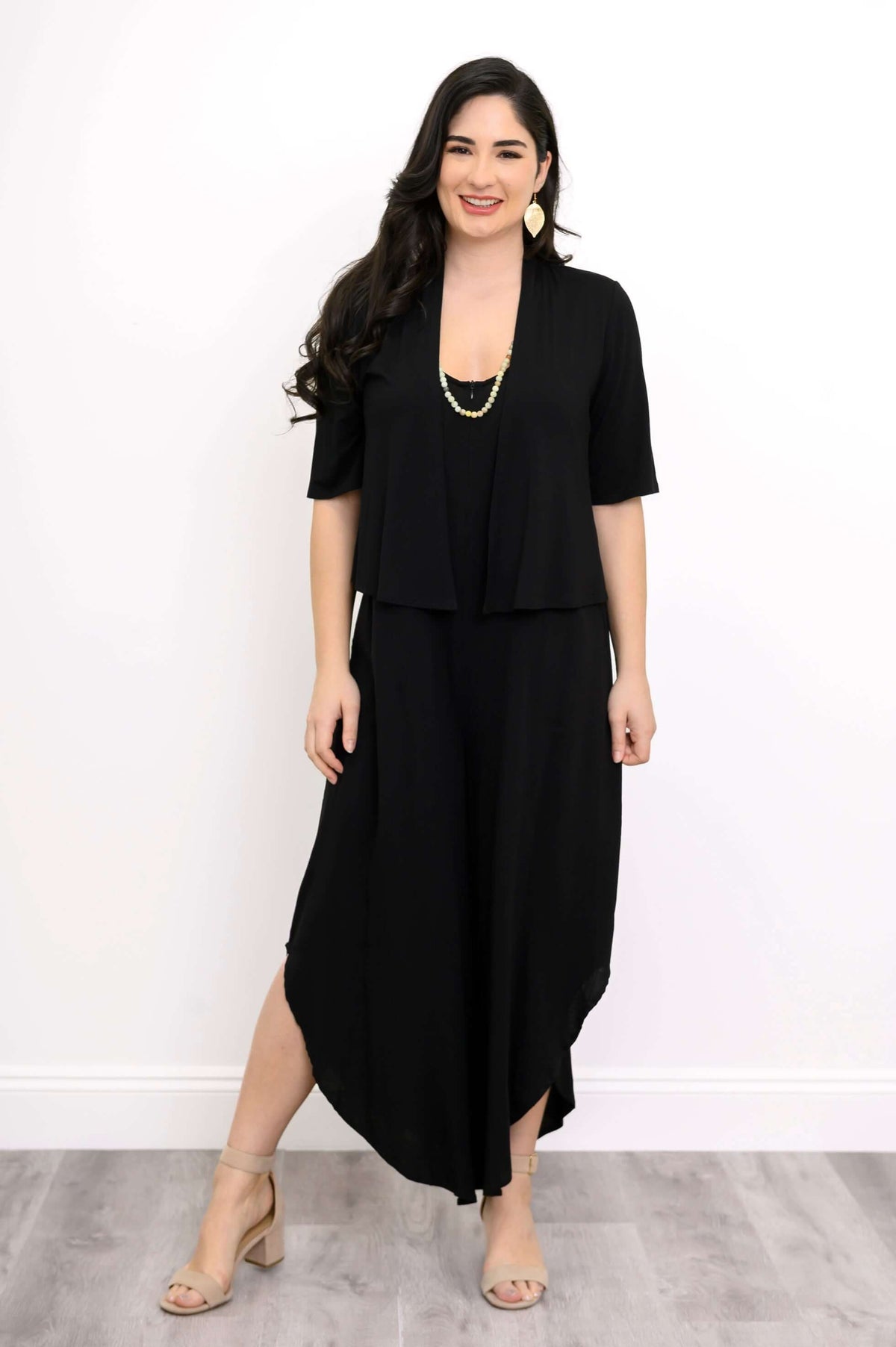 Model styling black jumpsuit with open front short-sleeve black cardigan