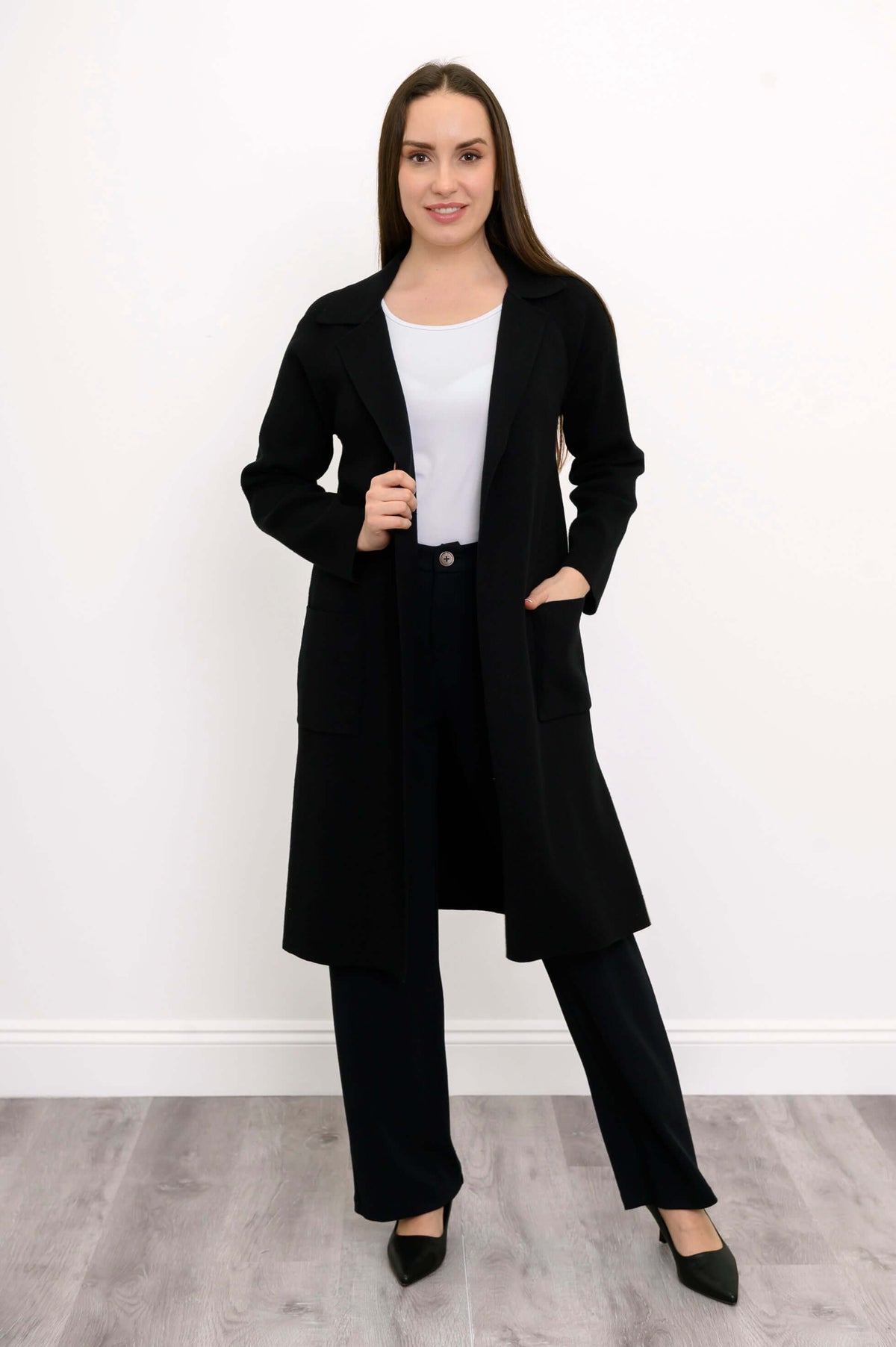 Model in black long sleeve cotton knit jacket with open front and pockets