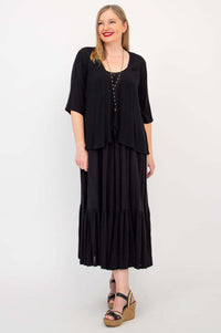 Woman modeling a black maxi dress layered with a draped black cardigan