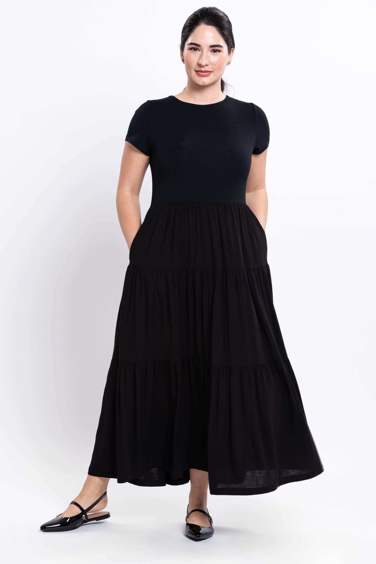 Woman showing pockets on a black short sleeve maxi dress