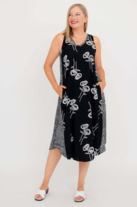 Woman posing in black summer tank dress with side pockets and white floral print