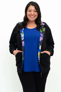 Front view of model showing open black zip hoody with floral lining and blue top