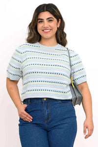 Woman wearing a light blue striped short sleeve sweater with navy and yellow details, styled with high-waisted jeans